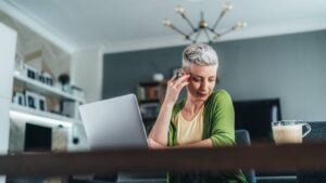 Businesswoman using laptop and documents, drinking coffee. Looking concentrated