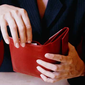 Businesswoman Opening Red Wallet at Table