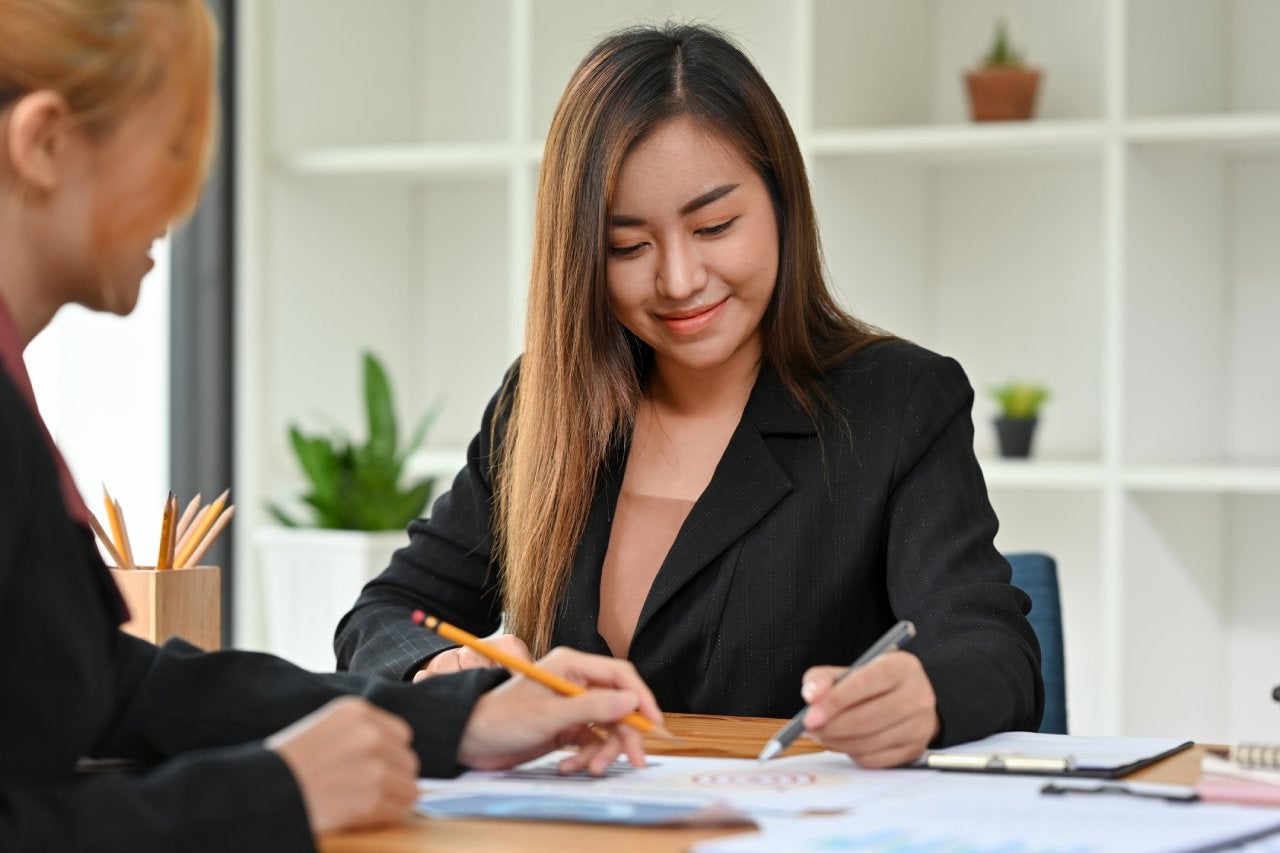 Asian woman signing papers