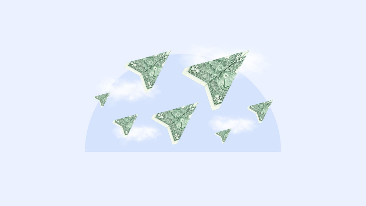 American dollar bills in the shape of paper airplanes on a background of clouds