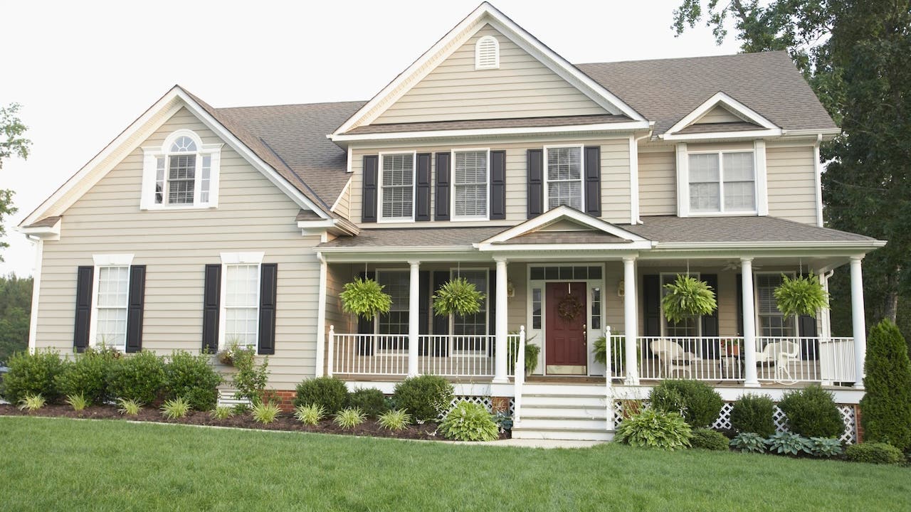 Cream-colored suburban house with large front porch