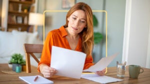 A woman perusing through some papers at her desk