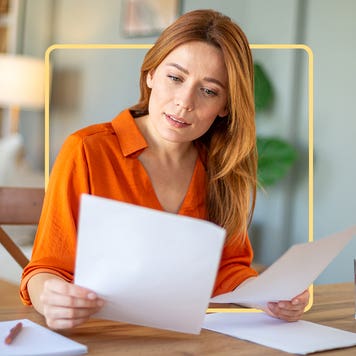 A woman perusing through some papers at her desk