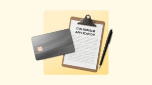 An ITIN number application on a clipboard next to a black pen and black credit card