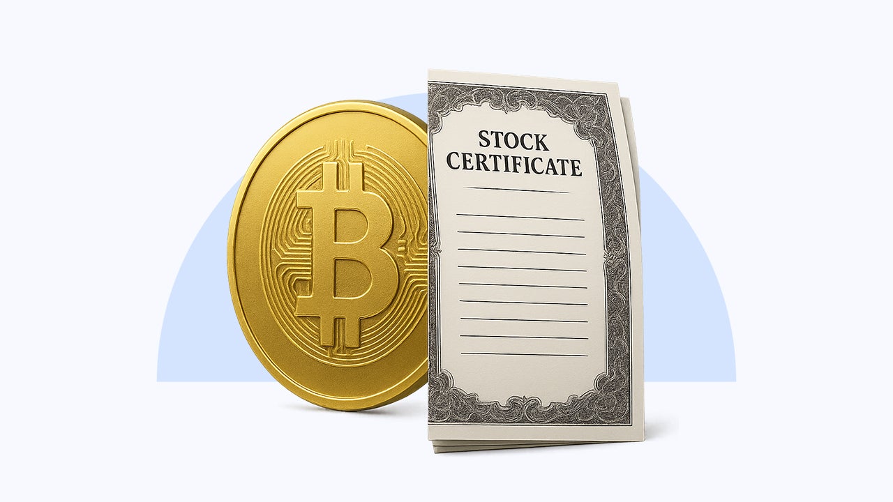 A bitcoin sits next to a stock certificate.