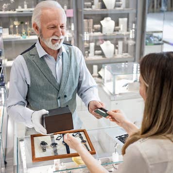 Young woman at a watch store buying with credit card