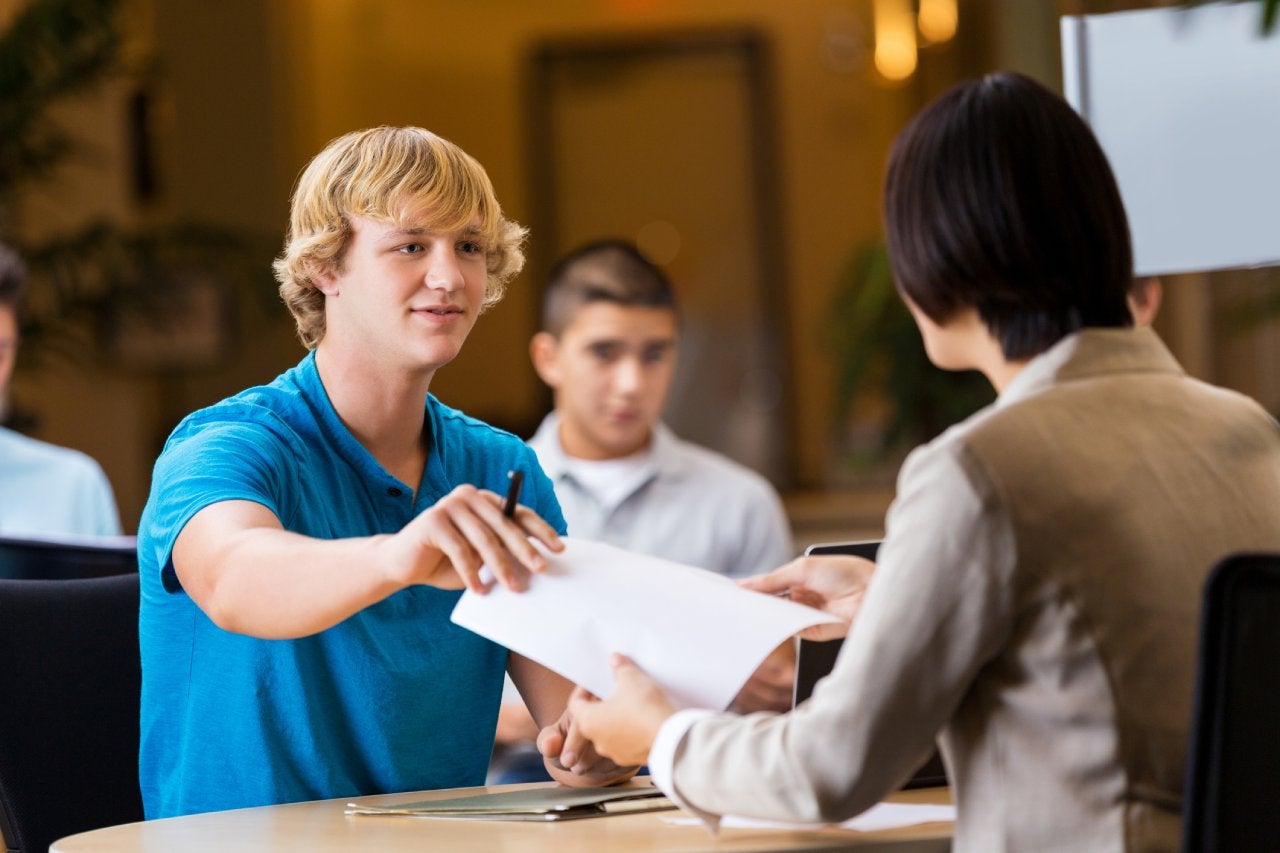 white male handing document to woman