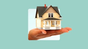 photo illustration of hand holding a yellow house