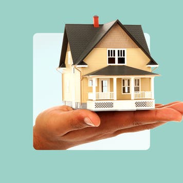 photo illustration of hand holding a yellow house