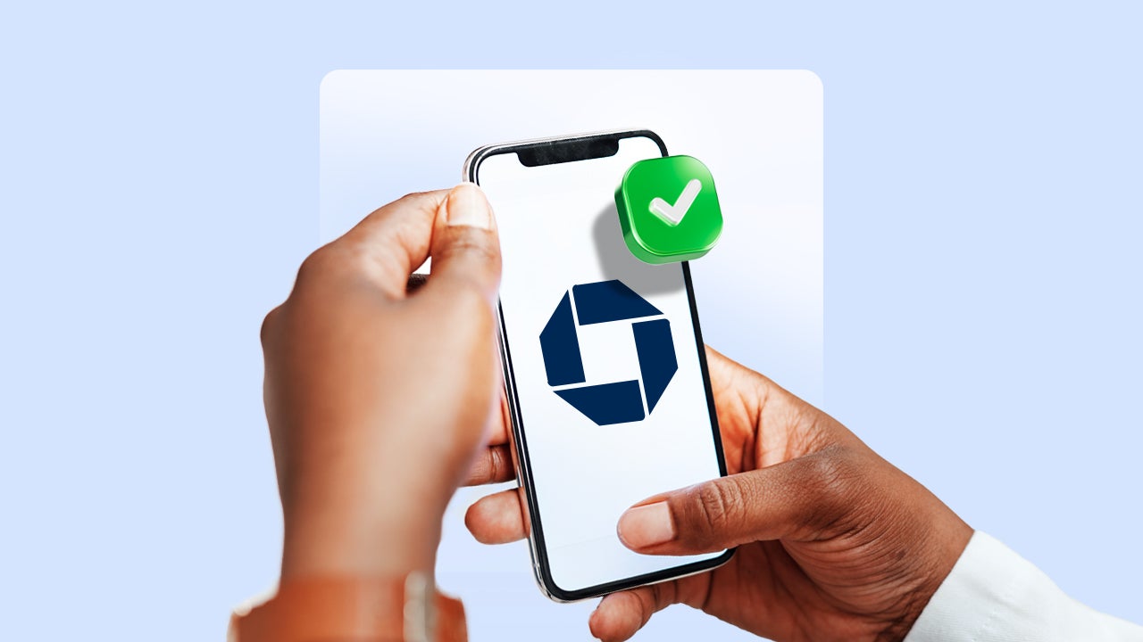 Hands holding a cellphone with a checkmark in the top right corner of it.