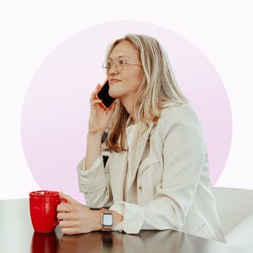 Katie Kelton holds a phone and coffee mug