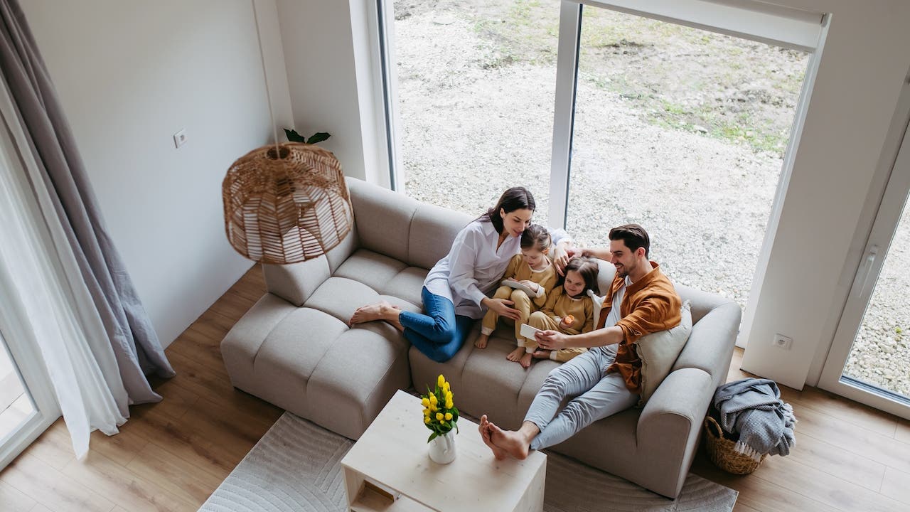 A top view of a young family sitting on a couch in their new home