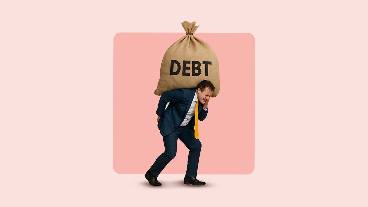 White man in black suit carrying a big bag with the word "Debt" on it