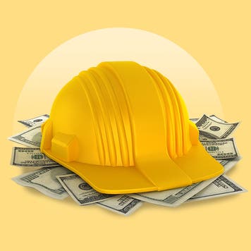 construction helmet on stack of money