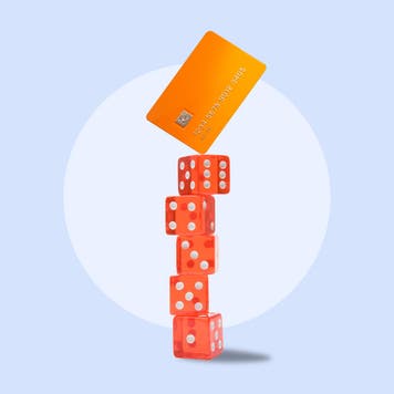 Design element of dice stacked with a credit card balancing on top.