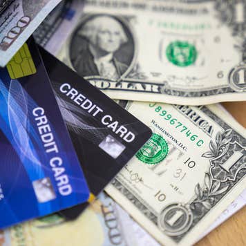 Credit cards lay on top of dollar bills