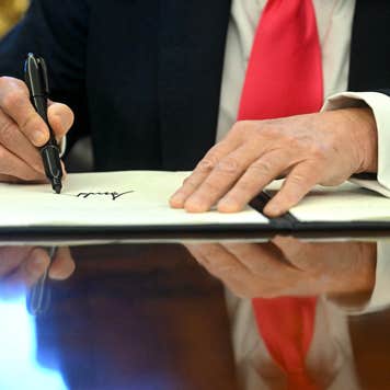 Close up of hands as Donald Trump signs executive order.