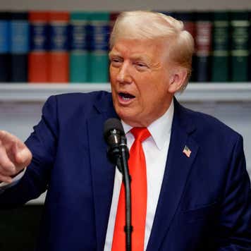 President Donald Trump speaks into a microphone at the White House.