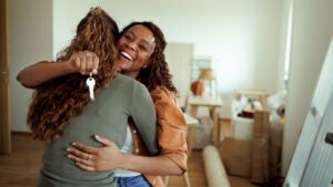 A couple hug in amid moving boxes in their new home