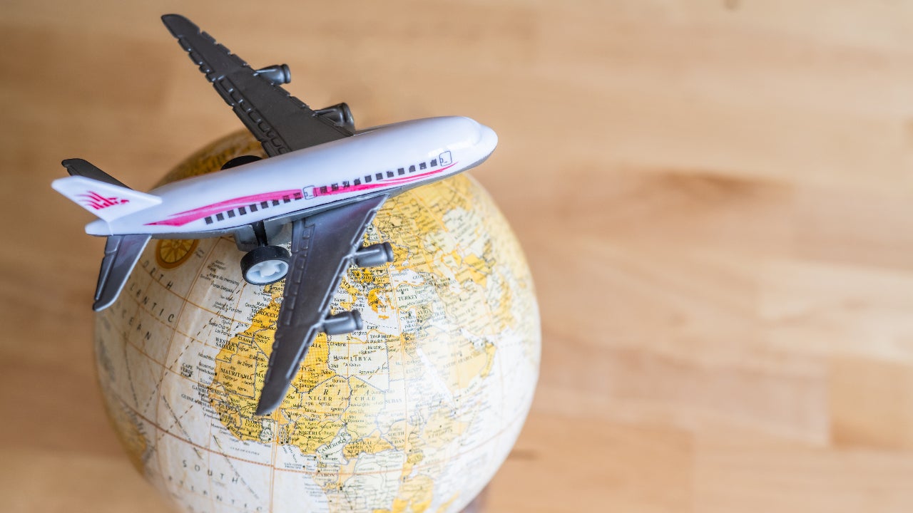 A miniature airplane sitting on a vintage globe