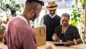 Couple making a purchase at flower shop counter with credit card
