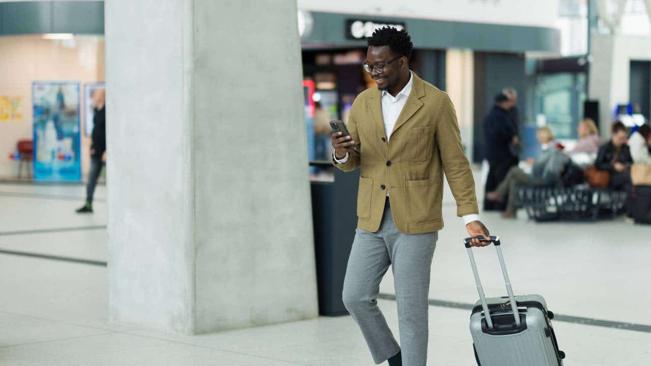 Business Professional Walking in Airport Terminal With Luggage