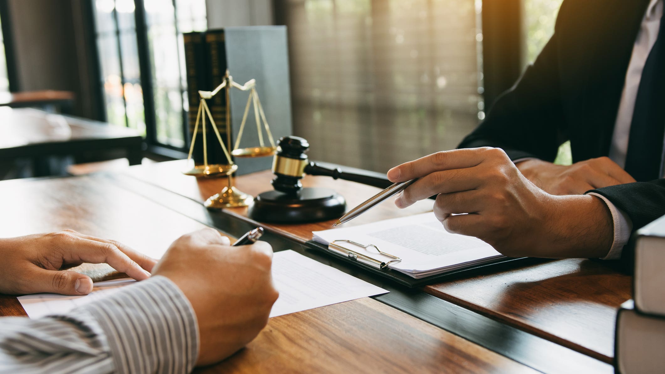 Lawyer is explaining about the wrongdoing laws regarding fraud to the client at the office.