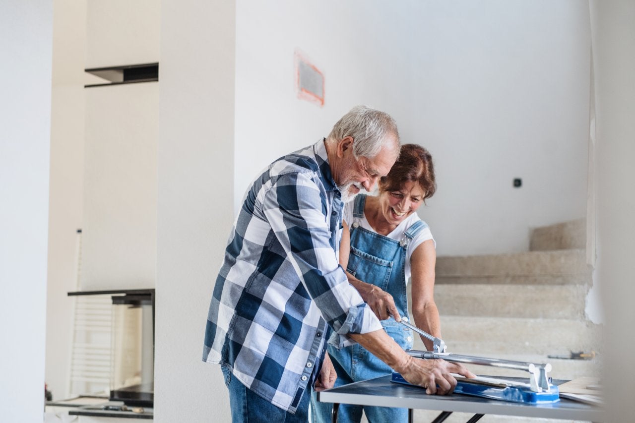 Old man and woman working on interior of new house or flat.