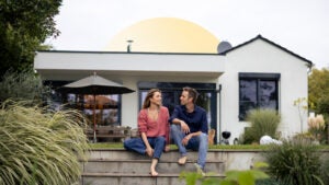 Couple sits in front of home