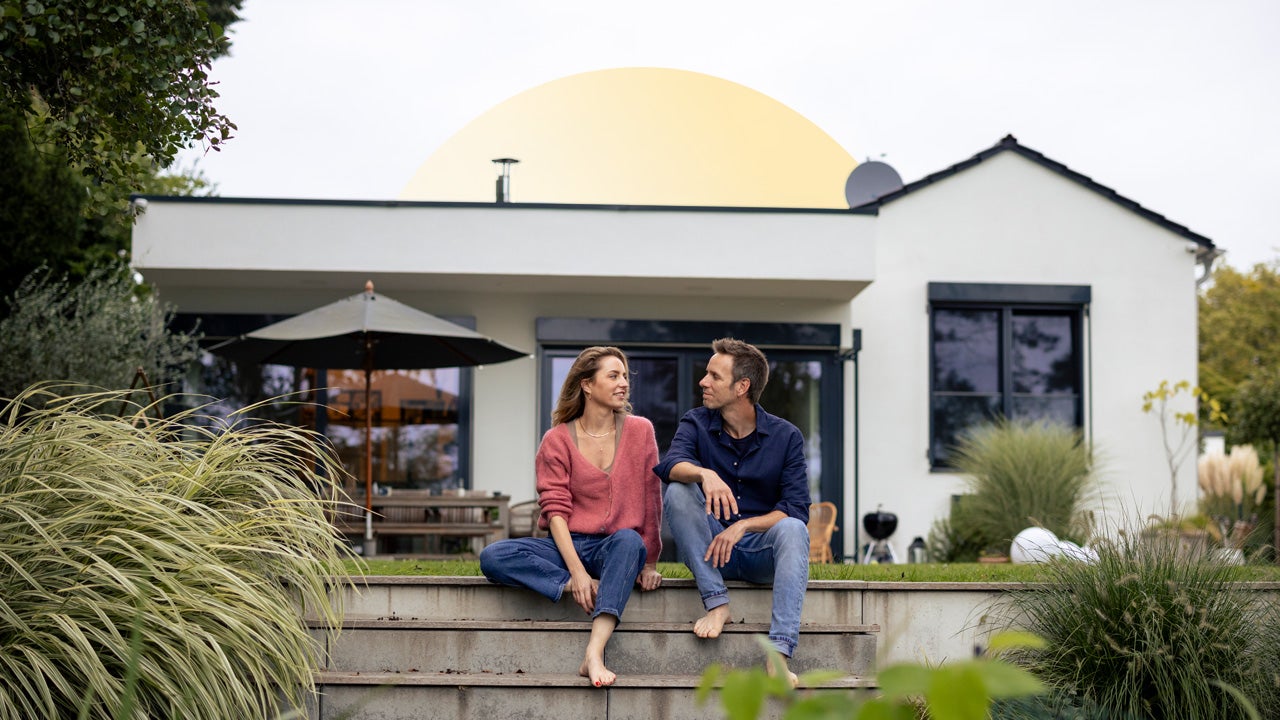 Couple sits in front of home