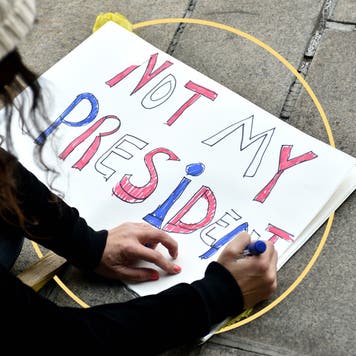 design image of an individual protestor writing out "not my president" on a poster