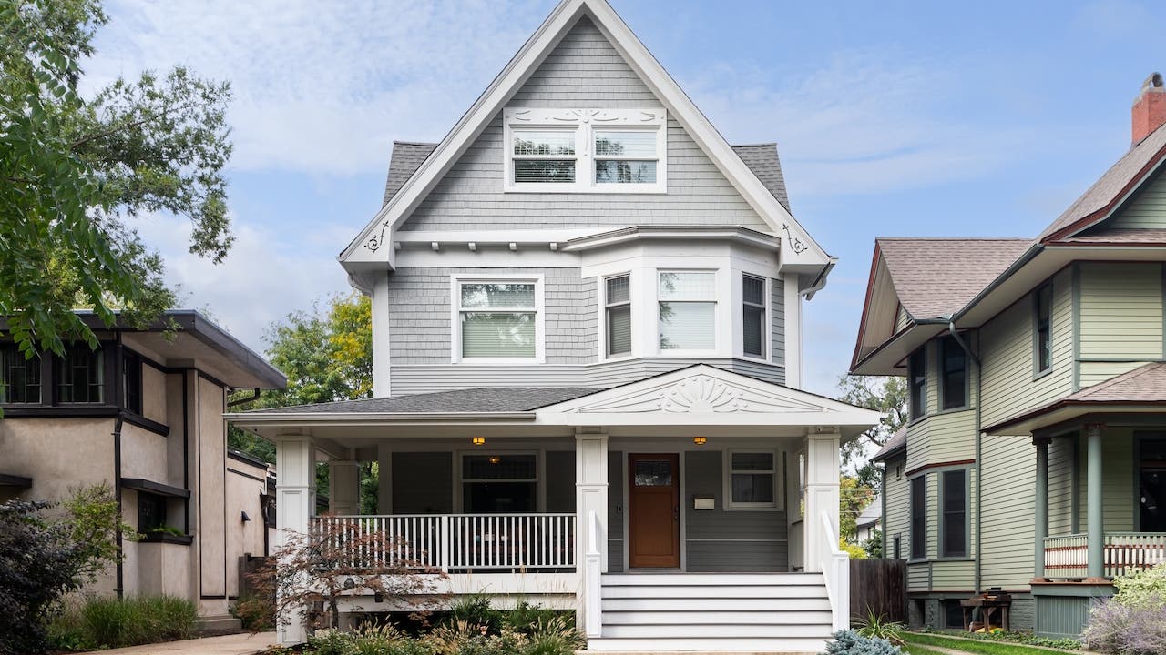 A grey and white victorian home exterior.