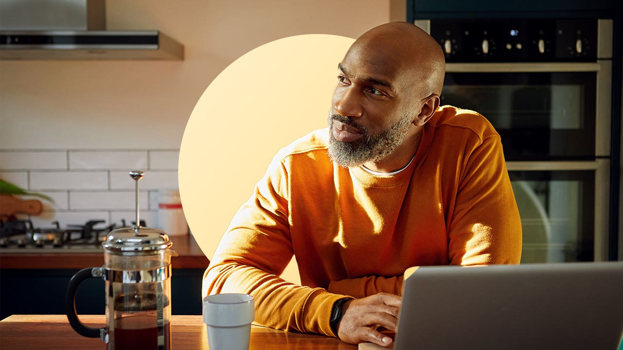 design image of a man smiling and looking to the side from his laptop