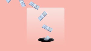 Pink background with stacks of 100 dollar bills (U.S.) falling into a hole.