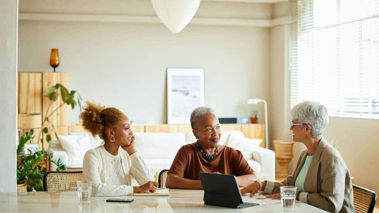 Mother and daughter are listening to finance manager. They are sitting at home.