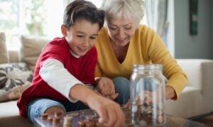Older woman and child putting pennies in a jar