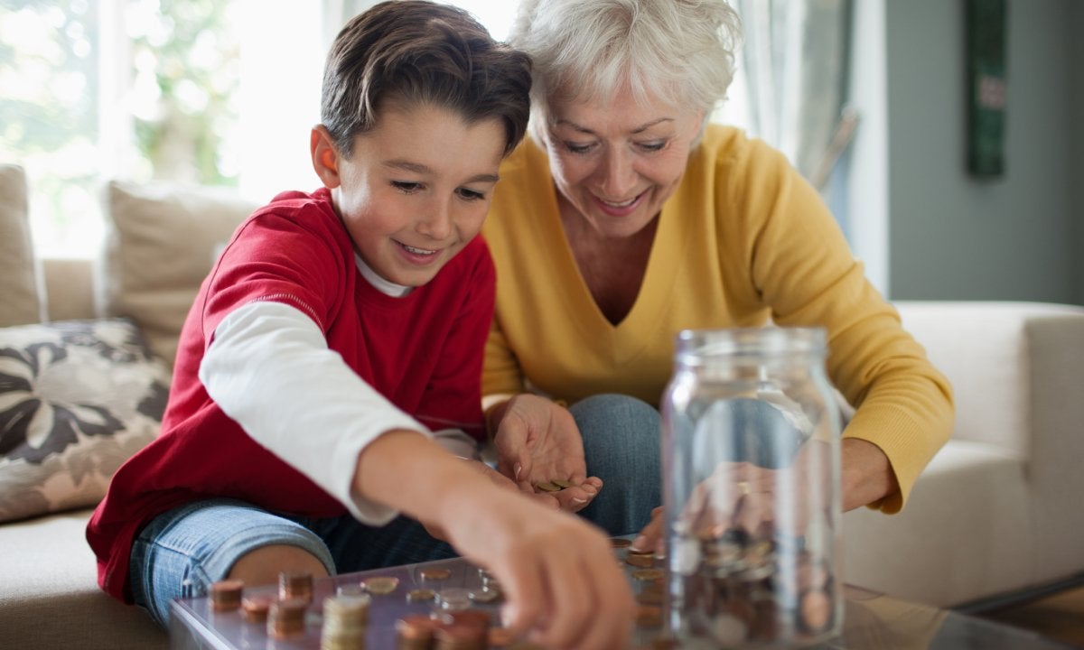 Older woman and child putting pennies in a jar