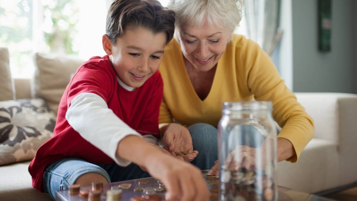 Older woman and child putting pennies in a jar
