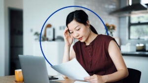 An Asian woman looks at paperwork