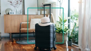 Design element featuring a travel suitcase with a sun hat sitting on top