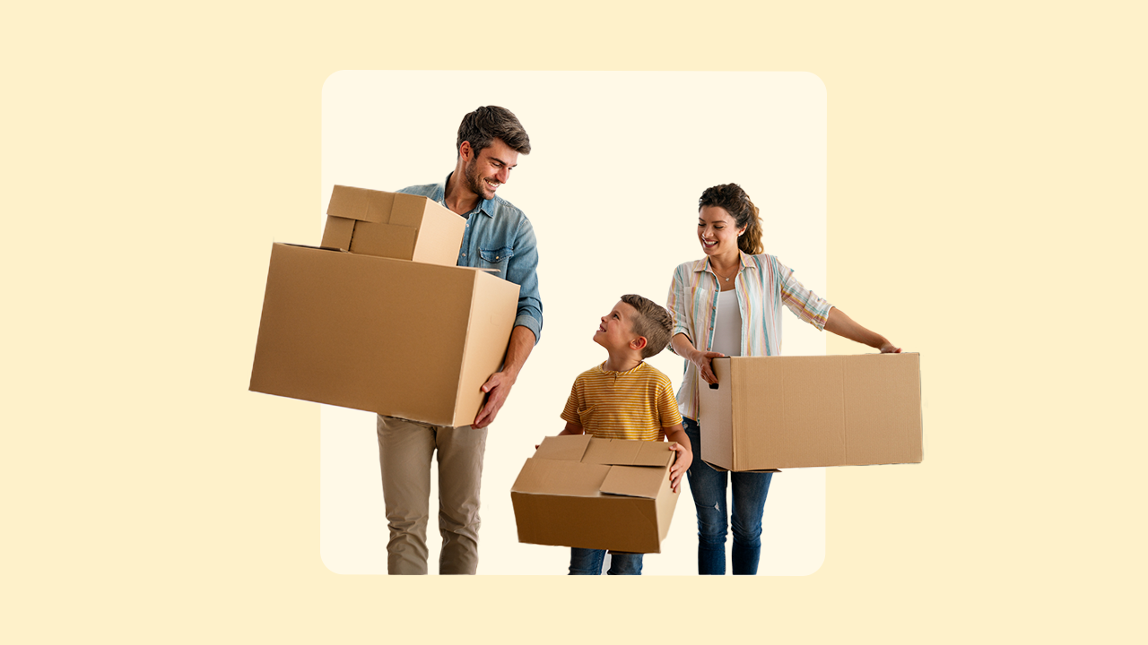 Family of three smiling and carrying boxes
