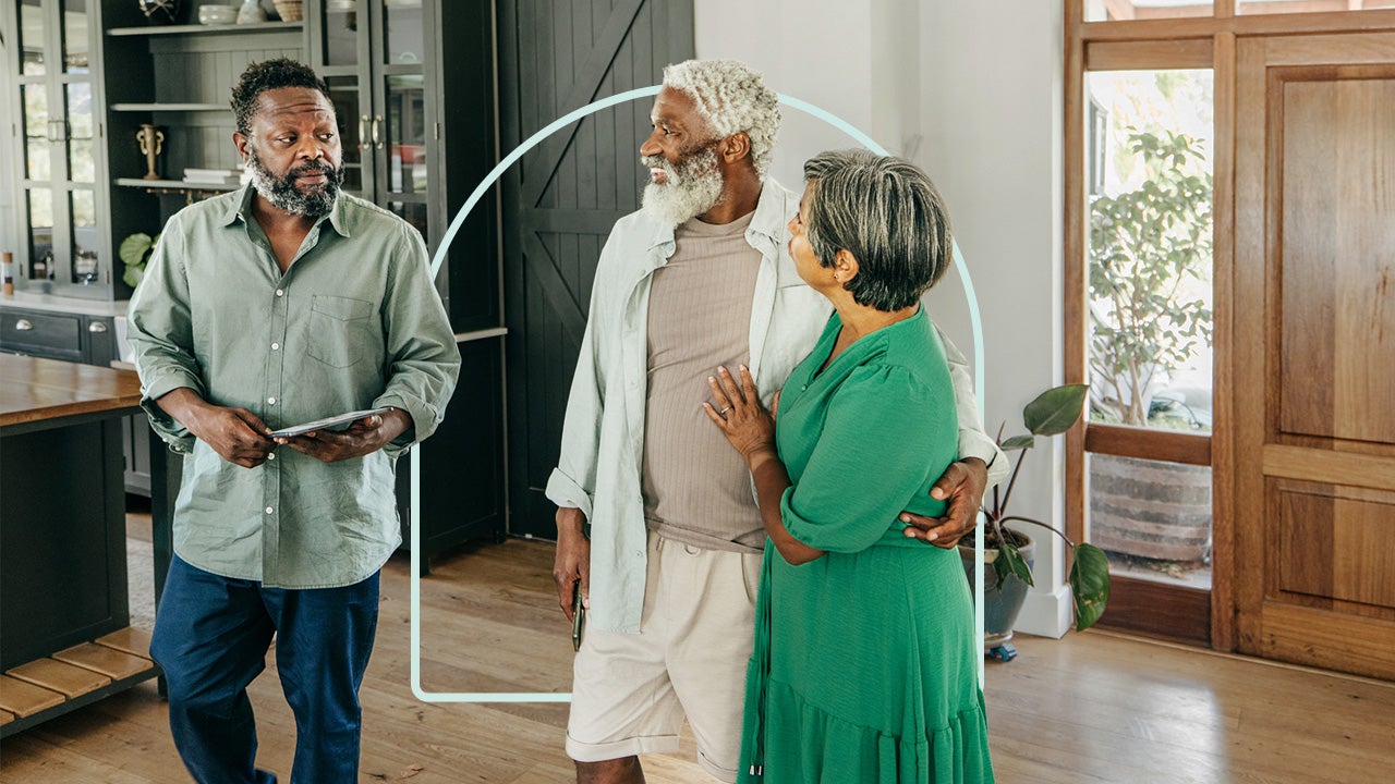 Smiling retired couple embracing each other while walking through home with their real estate agent