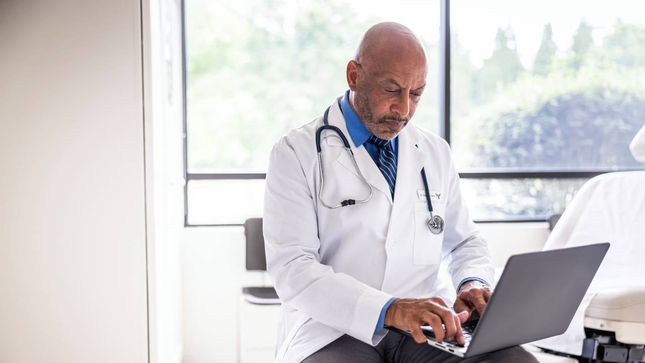 Doctor looking at laptop.