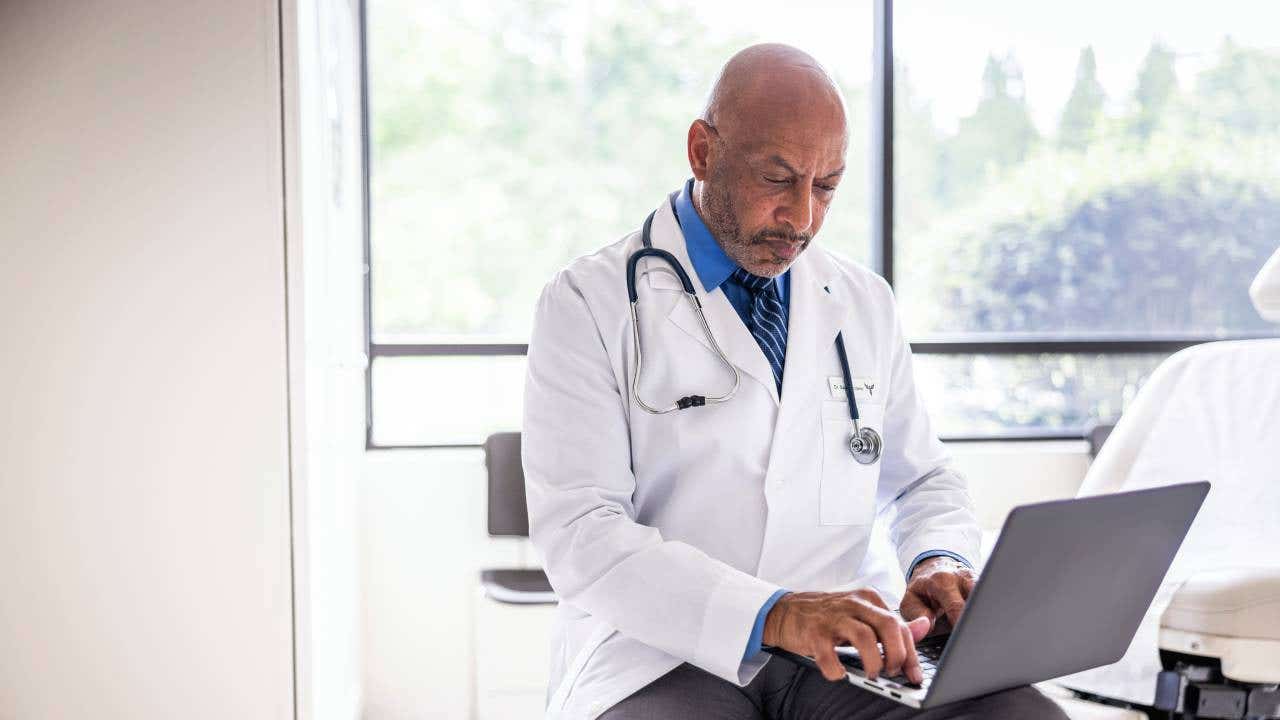 Doctor looking at laptop.
