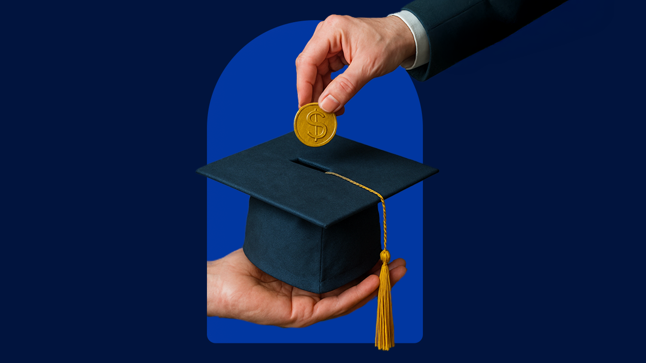 Hand holding a graduation cap with another hand inserting a coin into the top of the cap against a blue background.