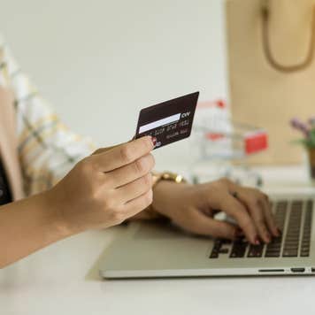 Hands at a laptop with a credit card.