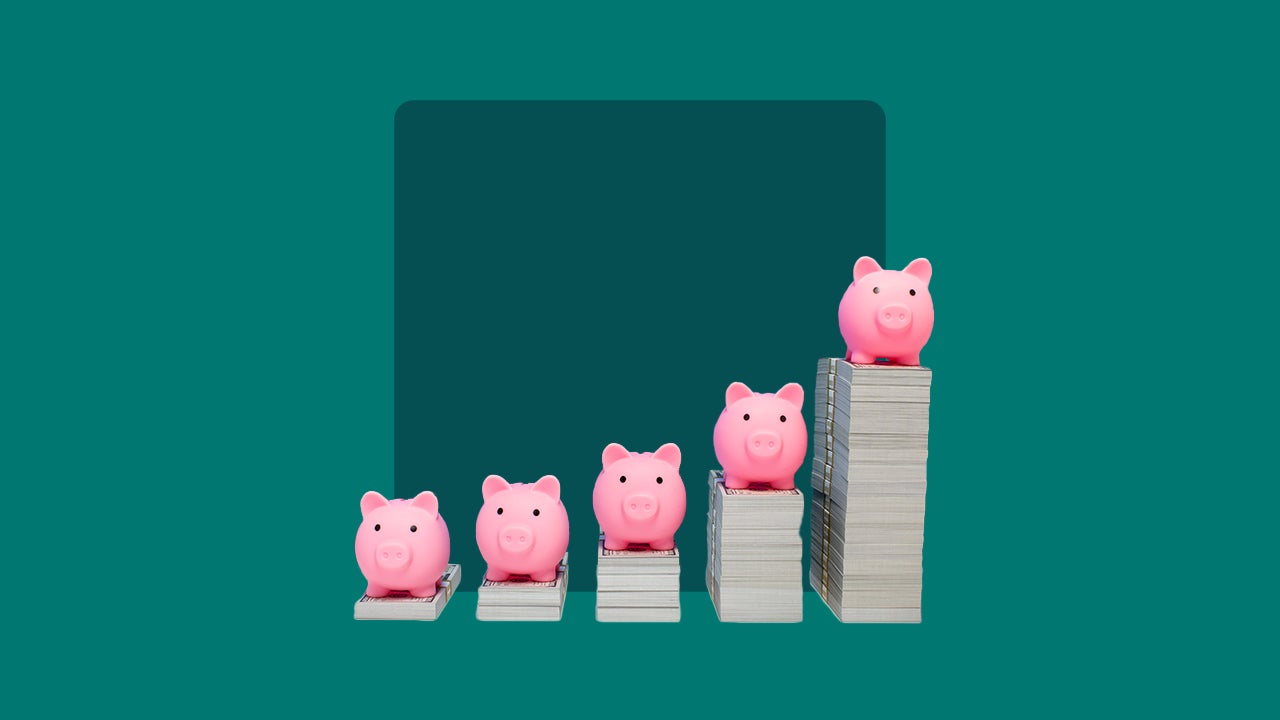 piggy banks on top of money stacks