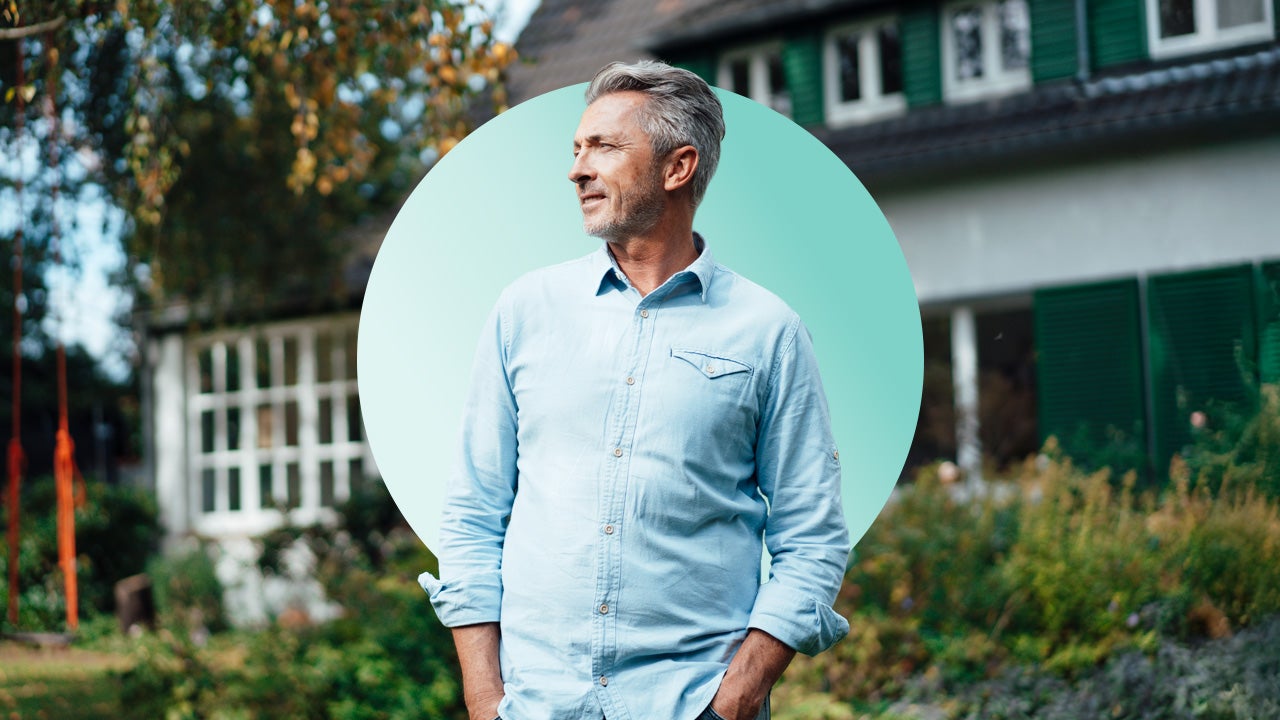 Middle-age man standing in front of his home looking at something in the distance