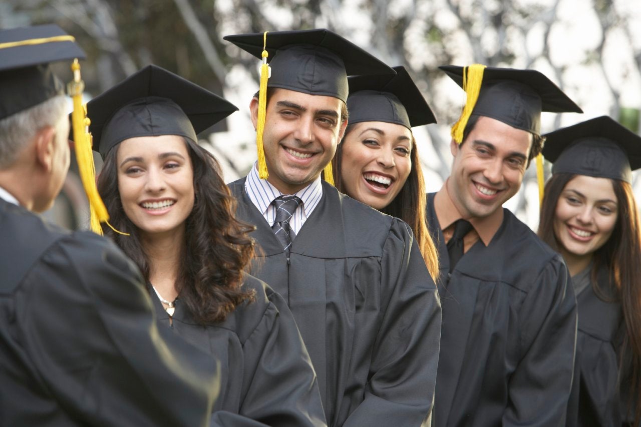 Graduate students standing in a row, outdoors