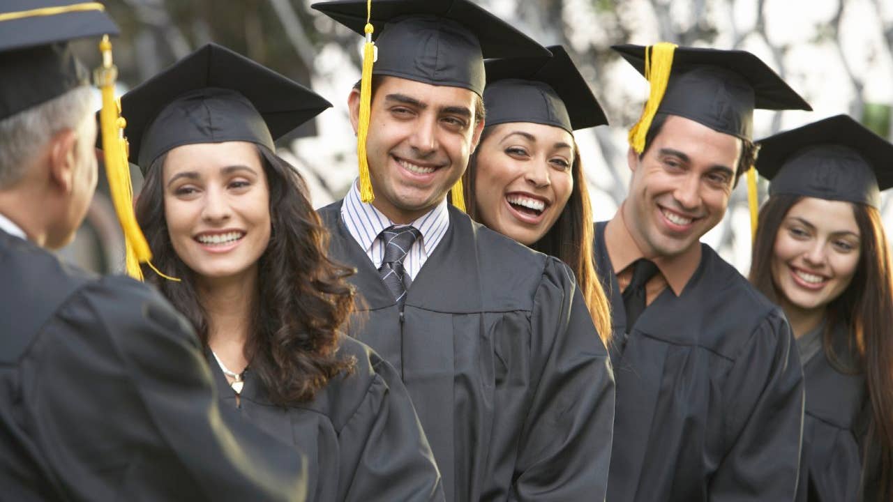 Graduate students standing in a row, outdoors
